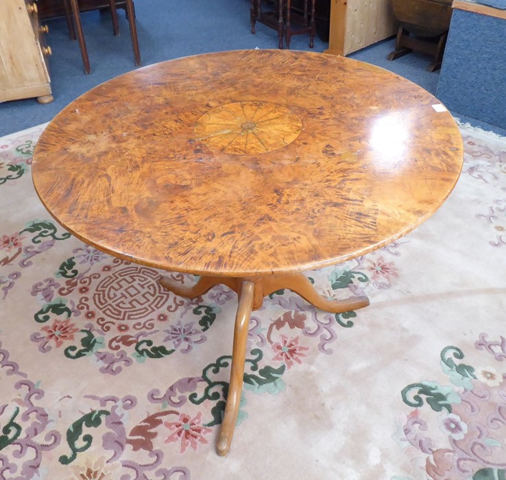 An unusual 19th century circular-topped figured walnut occasional table; turned stem and on tripod