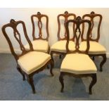 A set of five 19th century French walnut and upholstered salon chairs; the crest rails surmounted