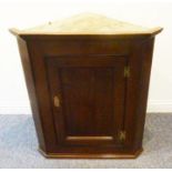 A late 18th century George III period hanging oak corner cupboard having single panelled door