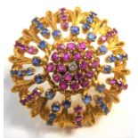 An 18-carat gold brooch set with diamonds, rubies and sapphires (10.2g) (The cost of UK postage