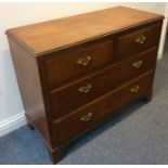 An early 20th century walnut chest; two half-width over two full-width graduated drawers raised on