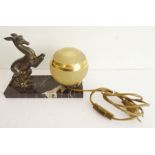 An Art Deco design table lamp modelled as a leaping gazelle before a glass sphere mounted upon a