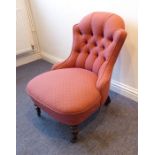 A late 19th century button-back upholstered low nursing-style chair; raised on high turned front