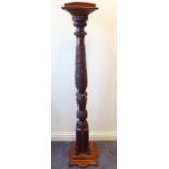 A finely carved mahogany torchere stand decorated in relief with leaves, thistles and other