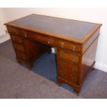 A Georgian-style walnut and feather-banded desk raised on bracket feet