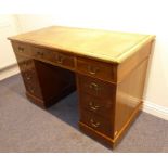 An early 20th century mahogany pedestal desk with inset green-leather top and raised on plinth base