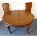 An early 20th century oval extending oak dining table having two extra leaves; moulded edge top