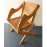 An antique (probably late 19th/early 20th century) waxed pine Glastonbury chair having panelled