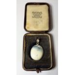 A milky-coloured cabochon hardstone silver-mounted pendant (boxed) (The cost of UK postage via Royal