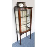 An Edwardian mahogany and boxwood-strung bow-fronted display cabinet; the galleried top with central