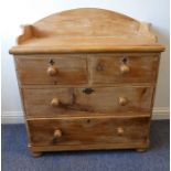 An early 20th century pine dressing chest; three-quarters galleried top over two half-width and