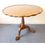 A mahogany tilt-top table with tripod base