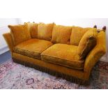 A large and fine upholstered drop-end Knowle-style sofa having carved and gilded pineapple