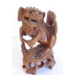 A finely carved 19th century Chinese model of a qilin-style creature with bifid tail; the front legs