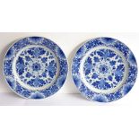 A pair of early 20th century Dutch Delft ware chargers; each centrally decorated with a flower