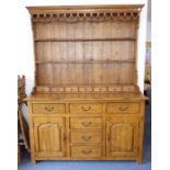 A large and stylish oak dresser; the outset cornice above a pierced frieze and shelving and the