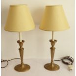 A pair of brass candlestick lamps and shades