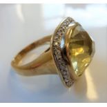 A large 9-carat gold ring set with a large citrine with diamond surround (9.1g) (The cost of UK