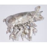 A heavy cast silver ornamental model of a recumbent sow and six piglets vying to feed (7.5cm wide,