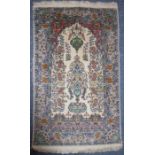 A fine hand-knotted silk mixture Persian prayer rug; various flower heads and stylised repeating