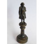 A small 19th century patinated bronze model of Napoleon upon a circular socle (12.5cm high)