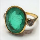 An 18-carat ladies ring set with a large emerald (15mm x 12mm, approx. 6 carat) flanked by two