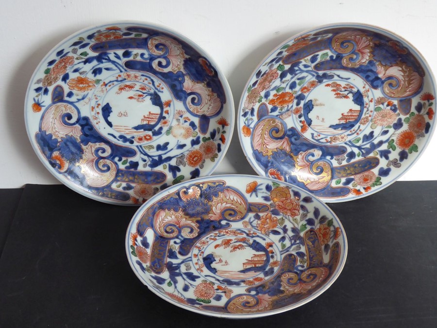 Three Japanese porcelain dishes; each hand gilded and decorated in the Imari palette with iron oxide