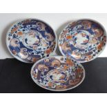 Three Japanese porcelain dishes; each hand gilded and decorated in the Imari palette with iron oxide