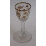 A facet-stem wine glass gilded in the manner of the atelier of James Giles Gilding is slightly