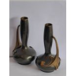 A pair of late 19th/early 20th century patinated bronze bottle vases; the gilded handles in high Art