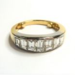 A seven-stone diamond ring; the graduated emerald-cut diamonds set in a line to the plain bi-