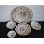 A porcelain group of mostly Meissen; a reticulated dish hand-decorated with a floral spray, one