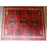 A Persian Shiraz rug with red ground and three central horizontal lozenges (156cm x 123cm)