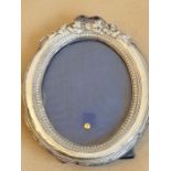 An easel-style silver photograph frame of oval section (damages) (18cm high)