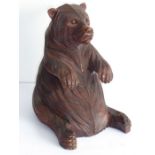 A 19th century carved Black Forest bear; the corpulent animal seated and with outstretched paws (