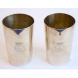 A pair of heavy, hallmarked silver beakers of tapering cylindrical form; light gilding to the