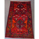 A north-west Persia Hamadan rug, predominately red ground with orange highlights (231cm x 145cm)