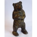 A late 19th century money bank in the form of a standing cast-iron bear (traces of original gilding)