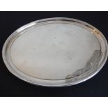 A Georgian-style oval silver-plated platter (armorial rubbed), raised reeded edge top above four