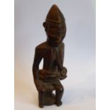A carved Congolese female figure with a babe in arms seated on a circular stool (20cm high)