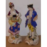 A pair of late 19th century hand-decorated continental porcelain figures; the lady with hair tied up