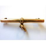 A yellow-metal T-bar brooch