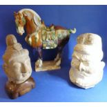 A Tang pottery head of a Lokapala, an Asian terracotta head on a hardwood stand and a Chinese