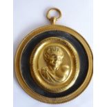 A 19th century circular gilt-metal wall-hanging relief study of a young male figure with curly