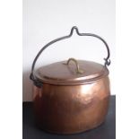A large 19th century oval copper cooking pot having iron swing handle and brass handle to the lid (