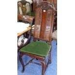 A late 17th/early 18th century walnut and rattan-caned high-back chair; the top rail carved with a