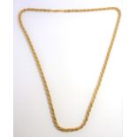 A yellow and white metal fancy link long chain necklace of entwined box link and cable link