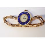 A lady's early 20th century 15-carat yellow-gold cased wristwatch; the outer case with blue-enamel
