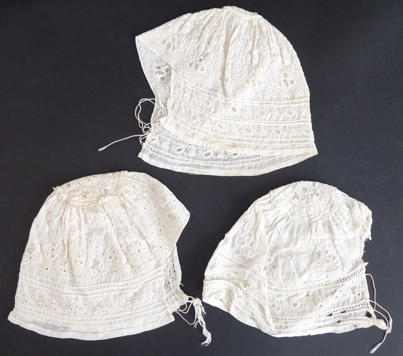 Three circa 1920s lawn embroidered baby's bonnets; ivory cotton lawn with broderie anglaise