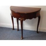 A George II demi lune fold-over top mahogany tea table; the double hinged top opening to reveal